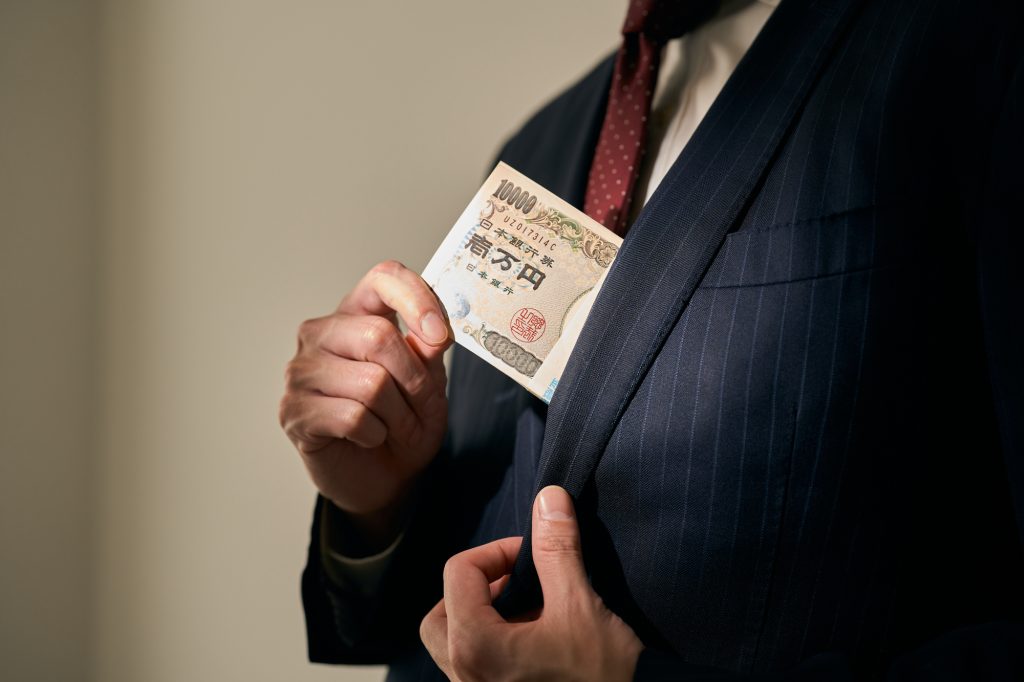 2024年 店舗経営 二極化 不正 横領 窃盗 現金着服 ブックオフ ハードオフ 三菱UFJ銀行 女性行員 札束をポケットにしまう男性